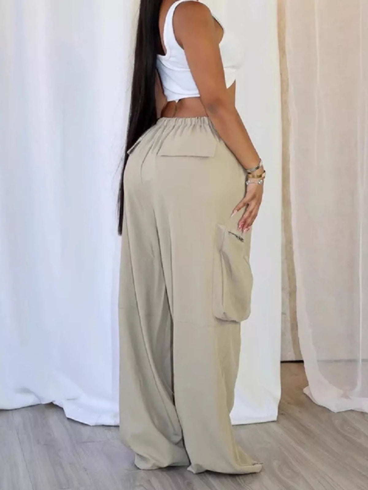 Drawstring cargo pants with zipper accents from Trendsi, featuring multiple pockets and a relaxed fit for casual wear.
