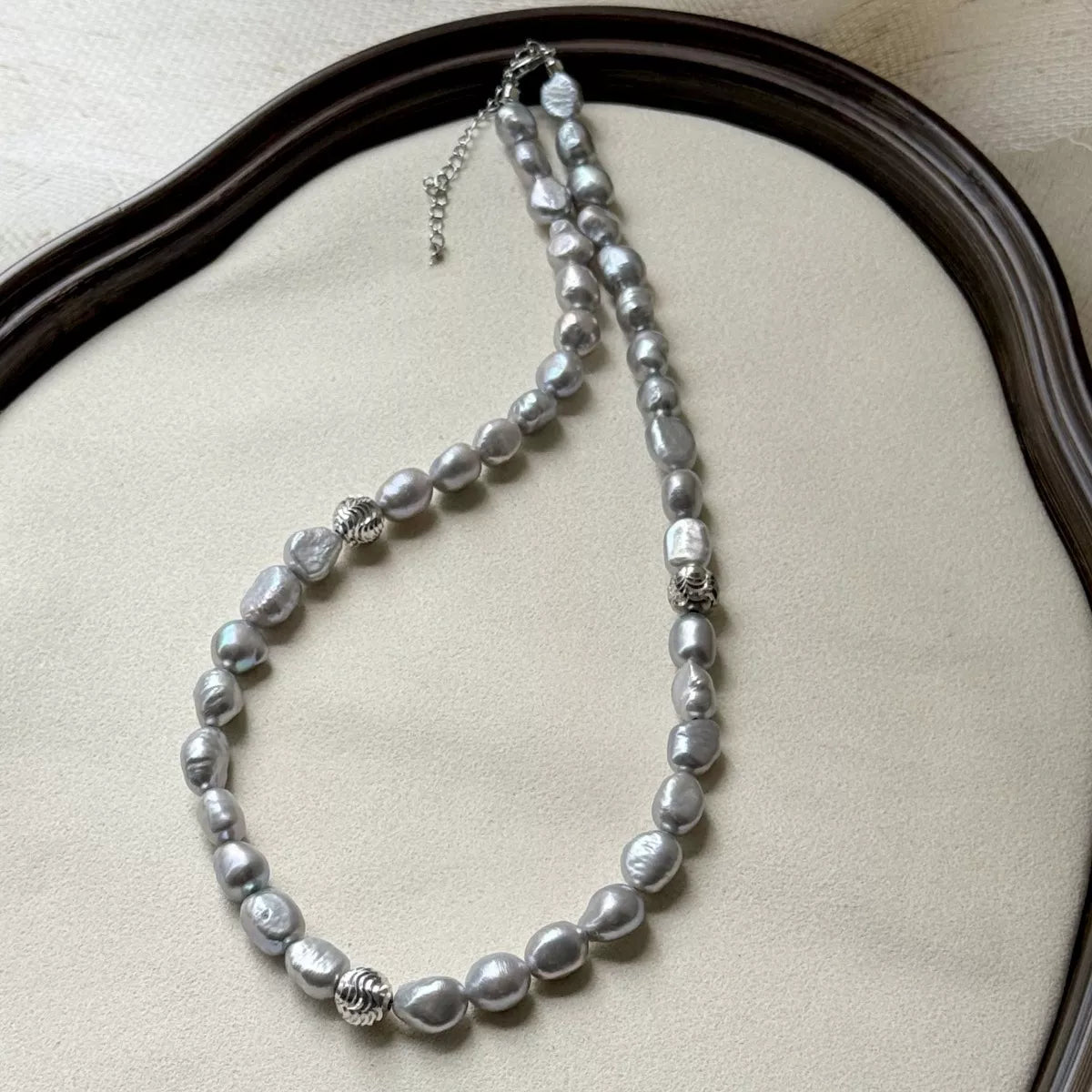 Pearl choker necklace from Plush Fashion Hub featuring a string of elegant white pearls on a delicate black cord.