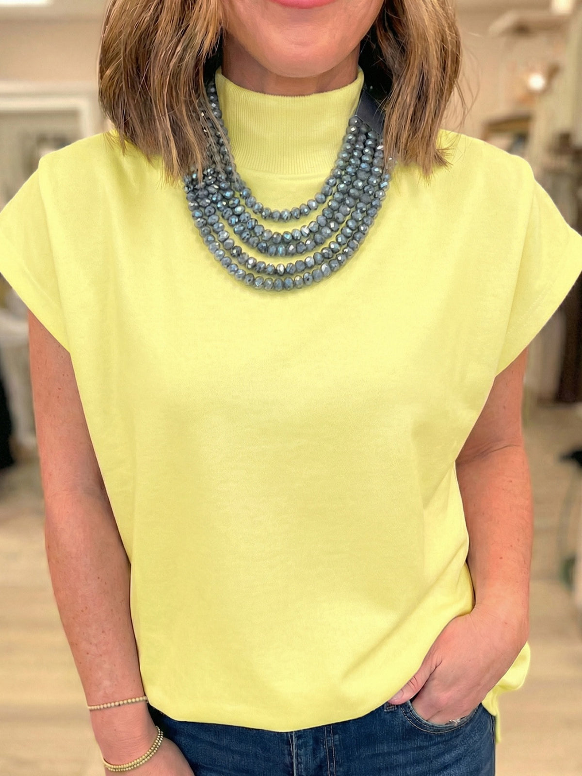 Women’s black mock neck cap sleeve blouse from Plush Fashion Hub, elegant stretchy office top with a fitted, basic design.