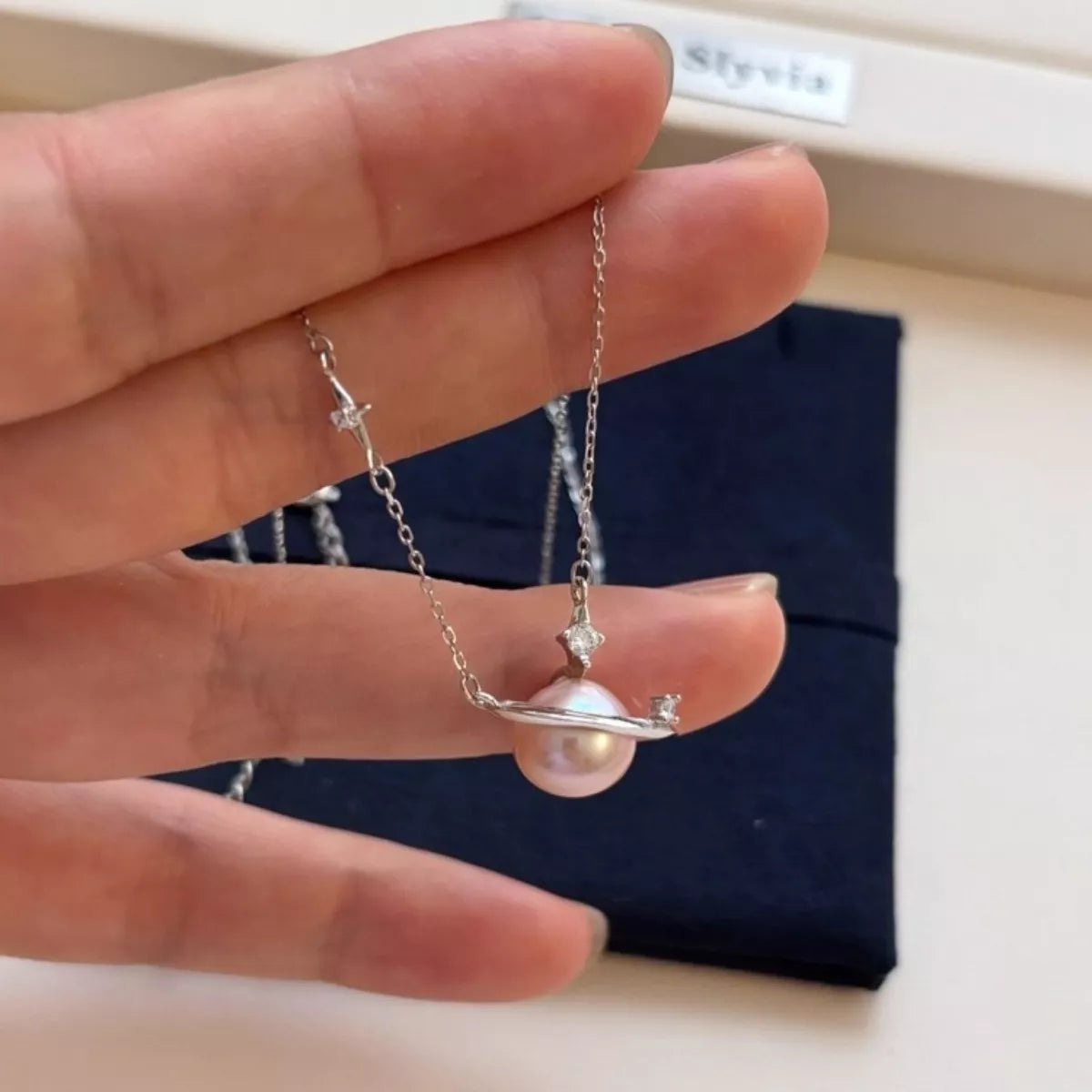 Plush Fashion Hub Planet Pearl pendant necklace featuring a shimmering pearl charm on a delicate chain.