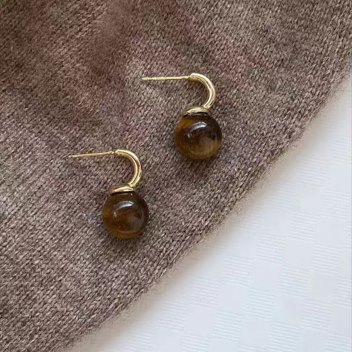 Gold-tone drop earrings featuring polished tiger eye balls from Plush Fashion Hub, stylish jewelry for everyday or special occasions.