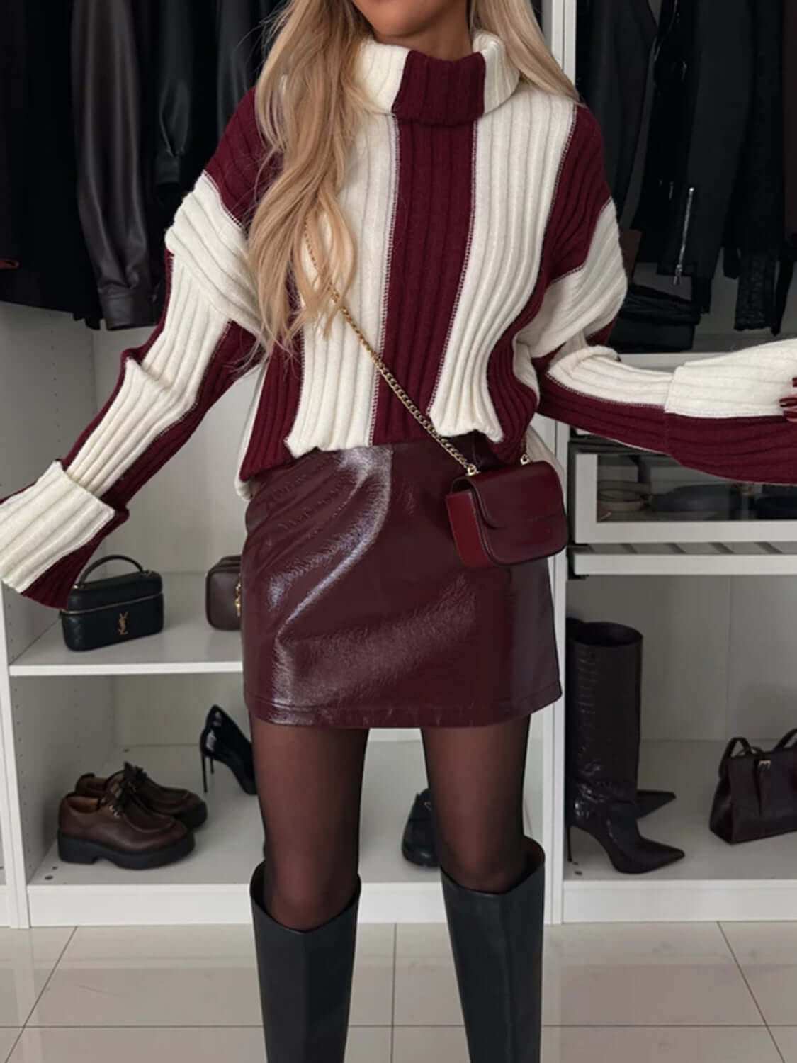 Striped turtleneck dropped shoulder sweater in burgundy and white, styled with a patent leather skirt and knee-high boots.