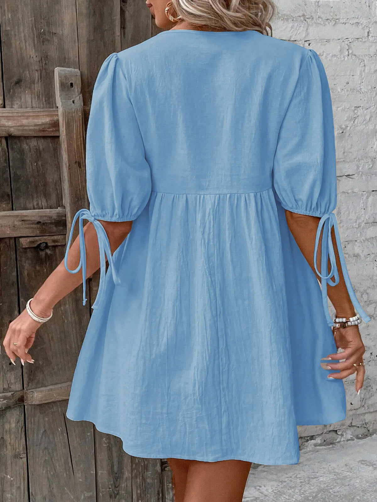 Cotton V-neck tie-front mini dress with puff sleeves by Plush Fashion Hub, shown in a stylish, casual design.