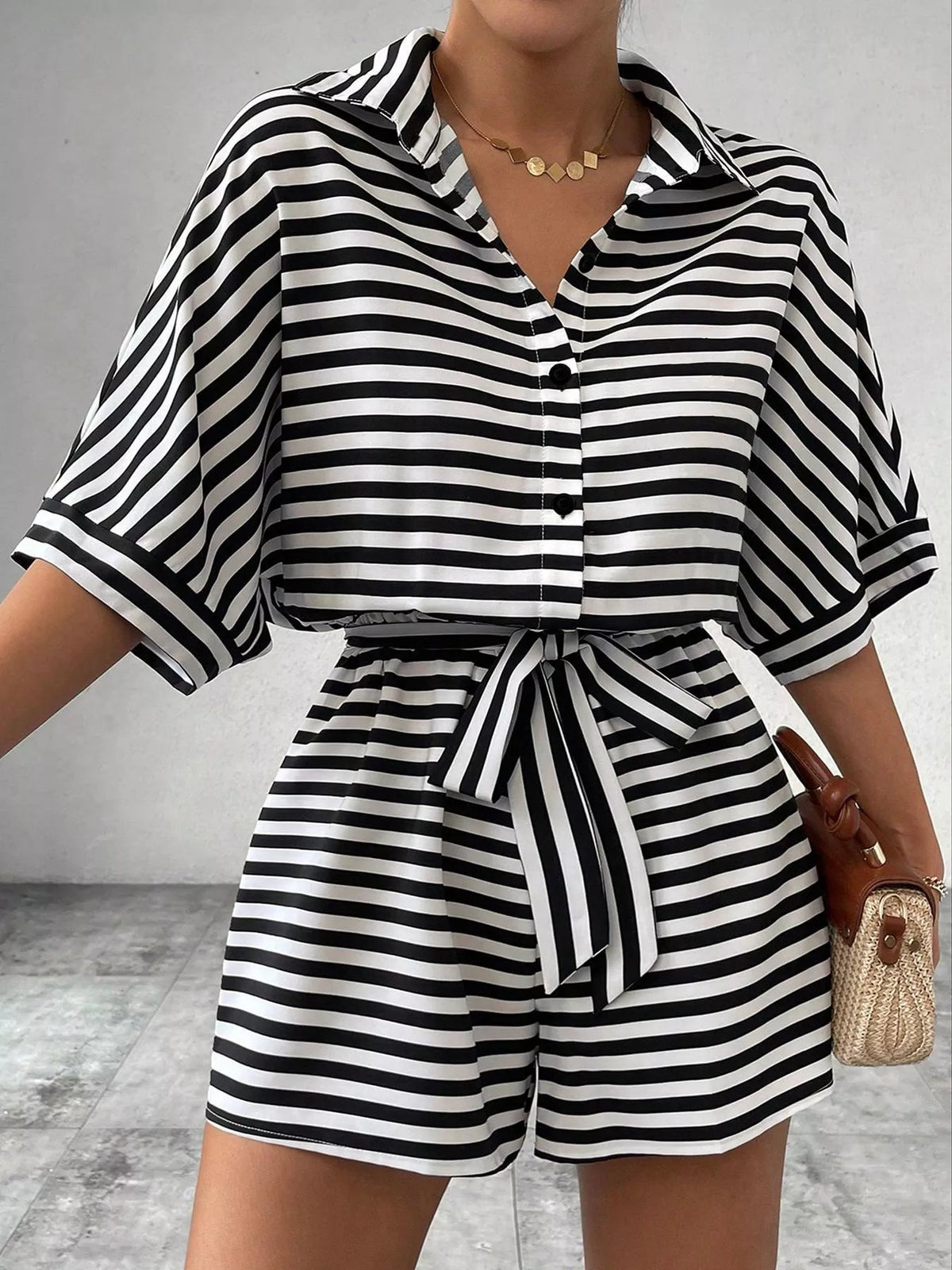 Striped button-up belted romper jumpsuit by Plush Fashion Hub, featuring a stylish design with a collar and waist tie.