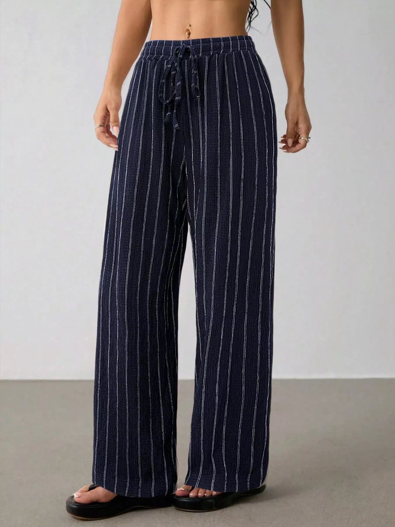 Striped wide-leg drawstring pants from Trendsi featuring a relaxed fit and comfortable waistband, perfect for casual wear.