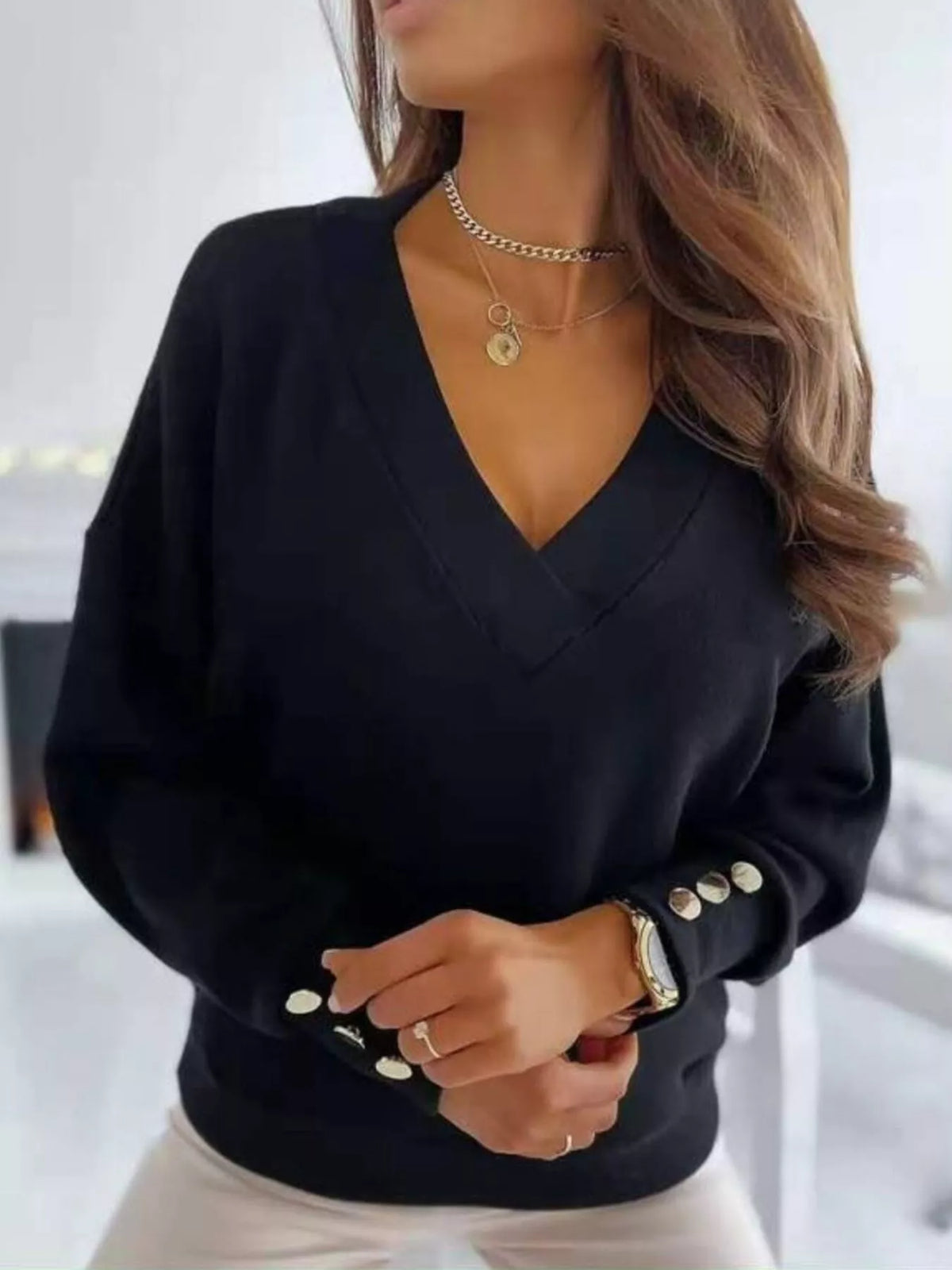 Womens V-neck button cuff blouse by Trendsi, featuring a lightweight fabric, V-neck, and buttoned cuffs, displayed on a neutral background.