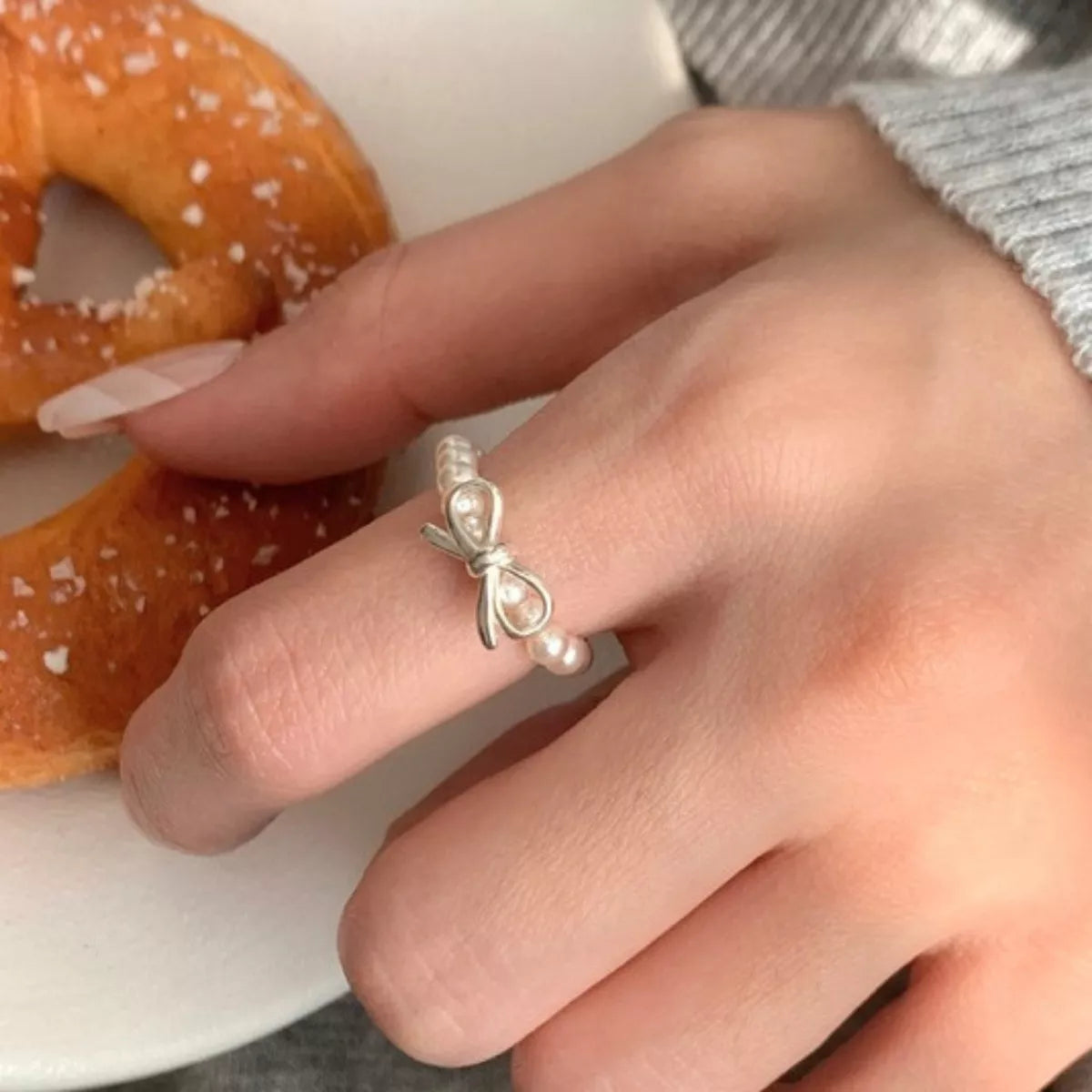 Pearl beaded ring with bow design by Plush Fashion Hub, elegant jewelry accessory featuring intricate beading and a charming bow detail.