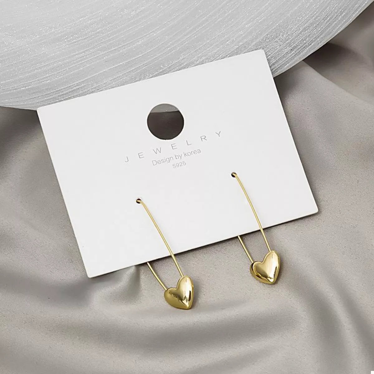 Gold-plated heart charm safety pin earrings with plush fashion design, featuring 18K gold plating and unique safety pin style.