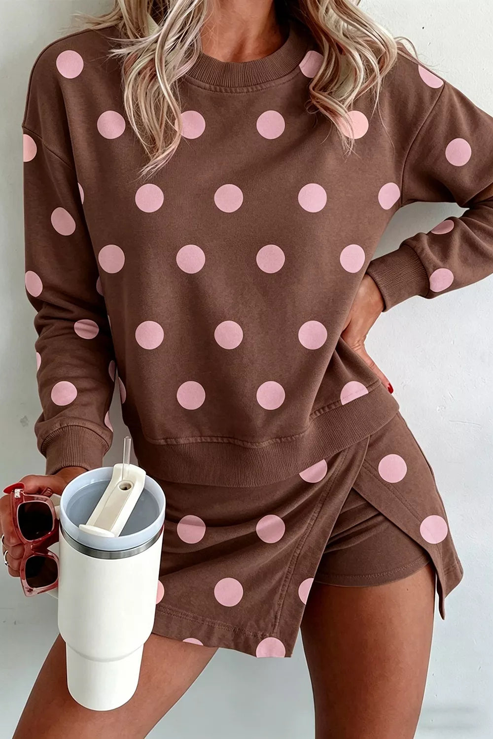 Polka dot women's sweatshirt and skirt set by Trendsi, featuring a casual matching top and skirt with playful pattern.