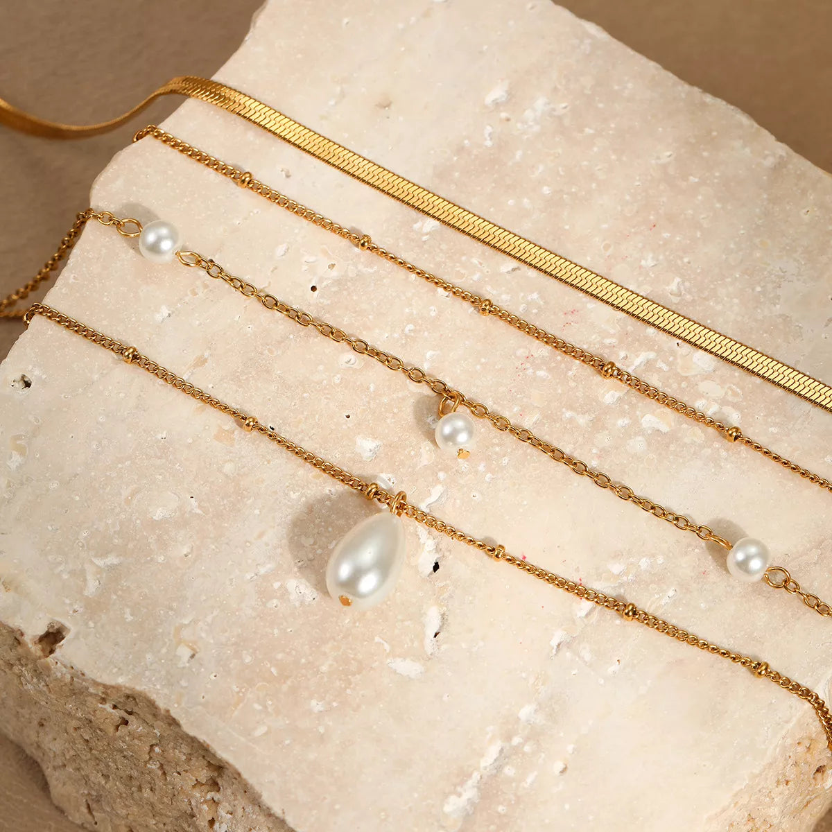 18K gold-plated four-layered pearl necklace with white pearls and gold accents, showcasing a luxurious multi-strand jewelry design.