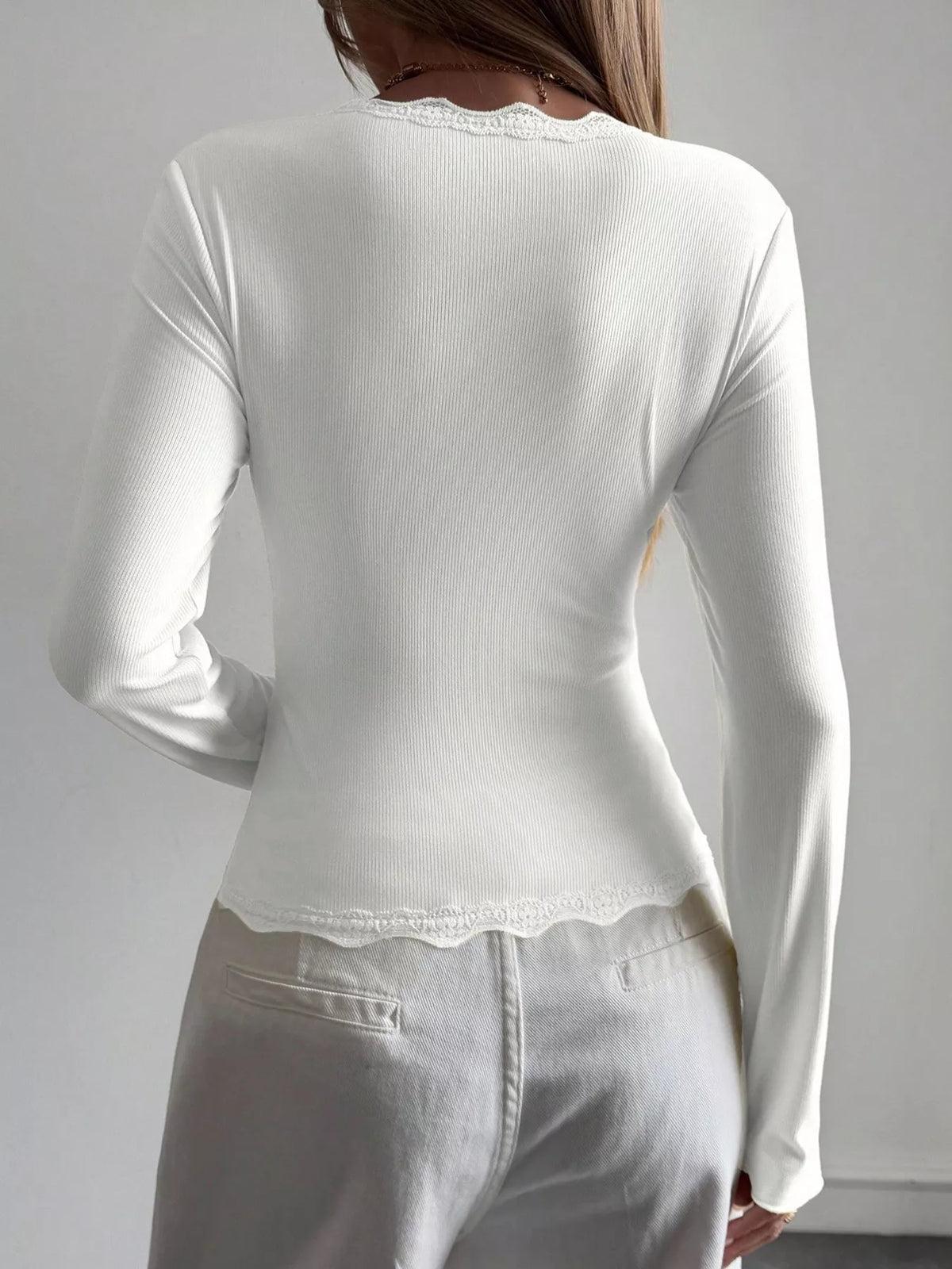 Ribbed long sleeve blouse with lace trim and V-neck from Trendsi, featuring a fitted design and elegant detailing.