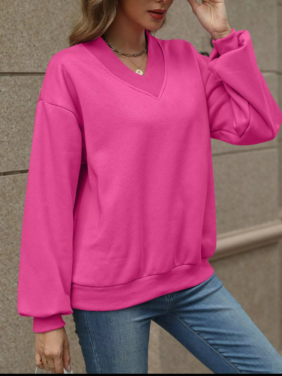 V-neck solid color casual sweatshirt from Trendsi, featuring a relaxed fit and soft fabric, ideal for everyday wear.
