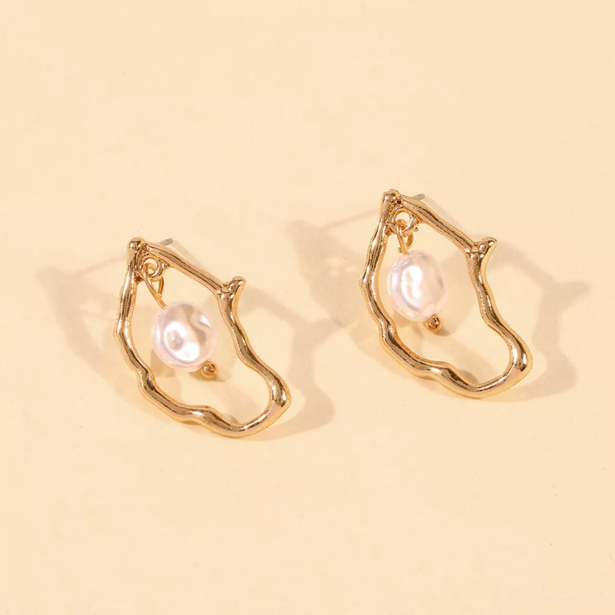 18K gold-plated pearl earrings featuring elegant round pearls and gold hooks, perfect for sophisticated style.
