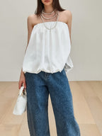 Women's strapless bubble hem tube top by Trendsi, sleek minimalist crop top with a fitted style and trendy design.