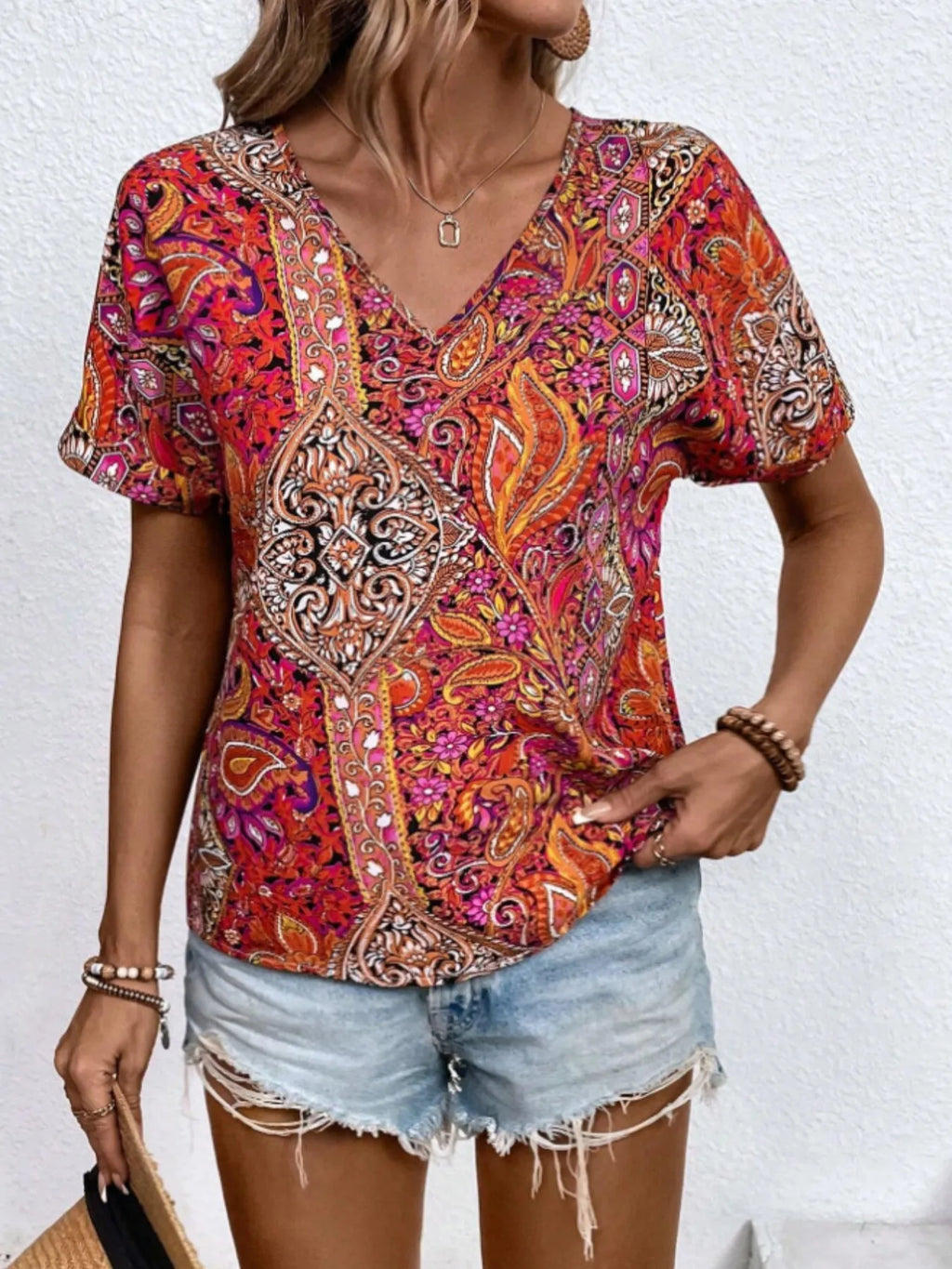 Bohemian paisley print V-neck short sleeve T-shirt by Trendsi, featuring colorful paisley pattern and relaxed fit.