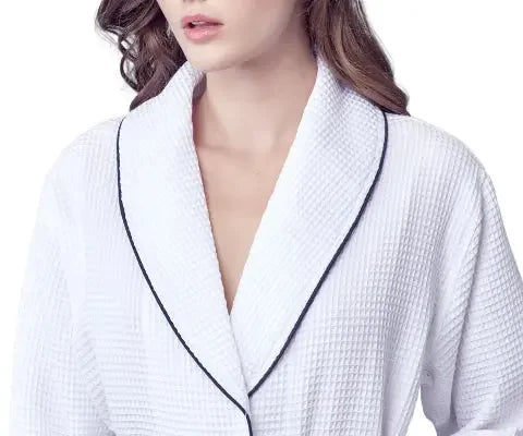 Front view of Lotus Linen women's knee-length waffle robe in white with piping, showing a cozy, lightweight bathrobe design.