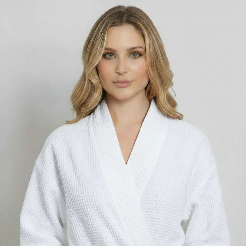 Front view of Lotus Linen women's knee-length waffle robe in white, showcasing its soft texture and cozy fit.