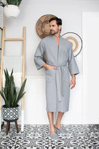 Gray Lotus Linen men's waffle spa bathrobe, lightweight and absorbent, shown hanging on a hook.