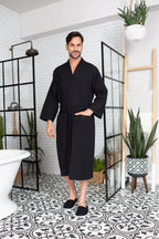 Men's Lotus Linen waffle spa bathrobe, lightweight and absorbent, shown hanging with a plush collar and tied waist.