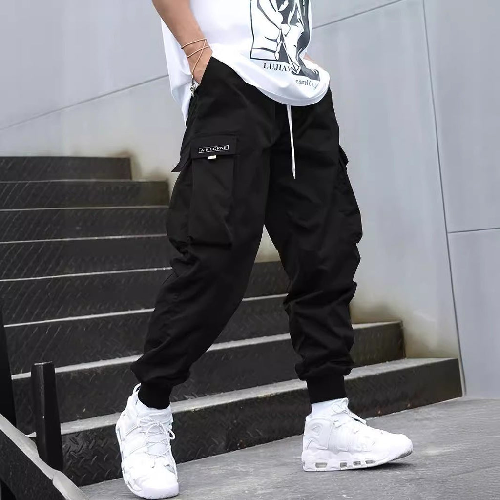 Men’s multi-pocket drawstring cargo pants from FitiqueFit, streetwear style with multiple pockets and adjustable drawstring waist.