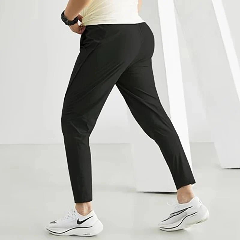Black men's quick-dry running joggers from FitiqueFit, designed for comfort and active wear, shown on a model.
