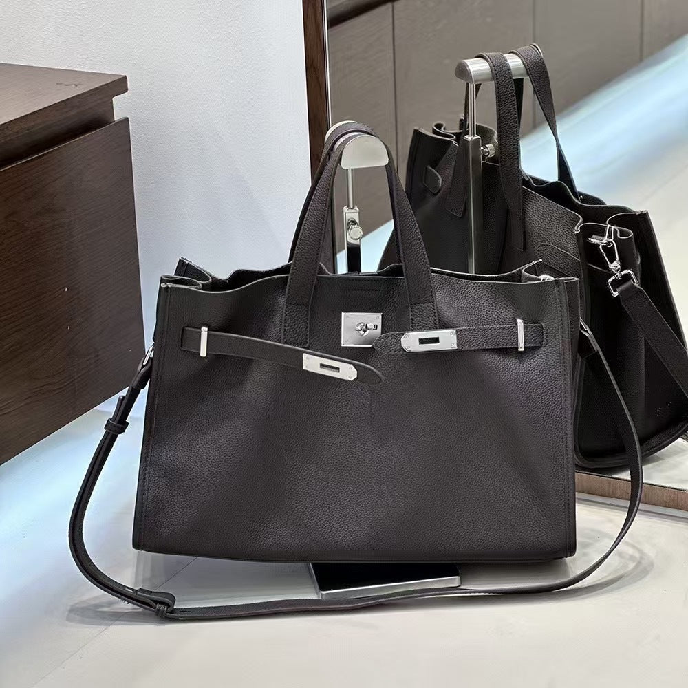 Black cowhide crossbody bag for women with adjustable strap and minimalist design, perfect for everyday use.