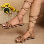 Women's open toe lace-up flat sandals in faux leather with a comfortable design, perfect for casual wear.