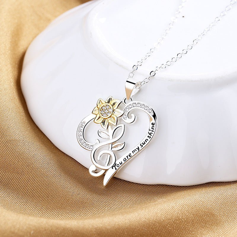 Pastoral-style two-color sunflower pendant necklace with heart-shaped chain, featuring a trendy design and layered look.