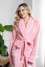 Soft pink Lotus Linen women's plush bathrobe hanging on a hook, showing its cozy, luxurious fabric and relaxed fit.