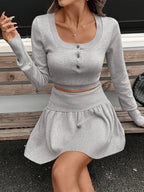 Women’s ribbed long sleeve top and pleated knit skirt two-piece set by Trendsi, stylish women’s apparel for casual wear.