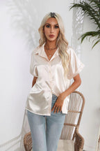 Woman wearing a loose-fitting satin short sleeve button shirt from Bella Mia, casual and stylish satin top for women.