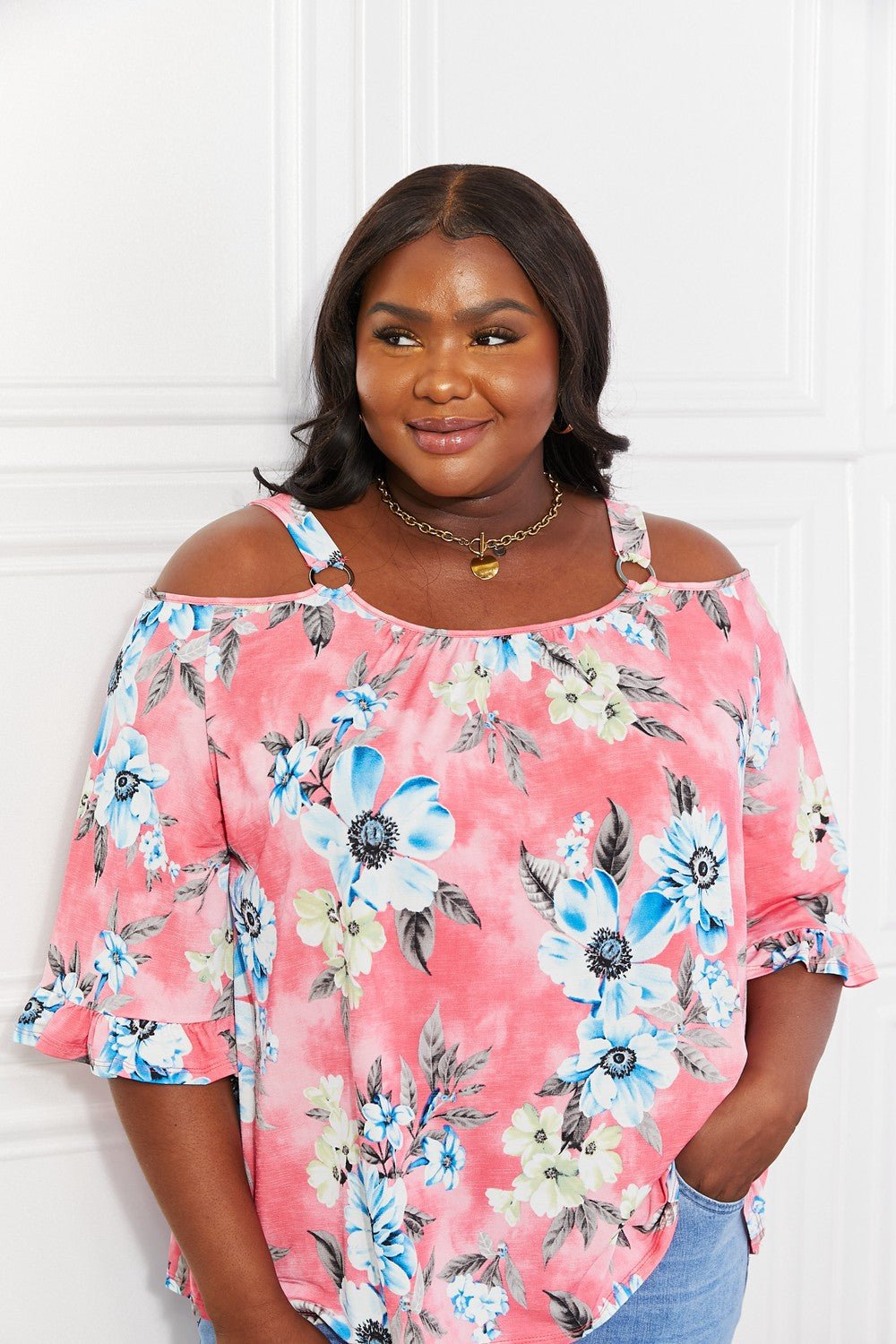 Floral cold-shoulder three-quarter sleeve women's top with metal ring details by Plush Fashion Hub.