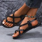 Women's faux leather flat sandals with strappy cross-strap design, perfect for casual wear and summer outfits.