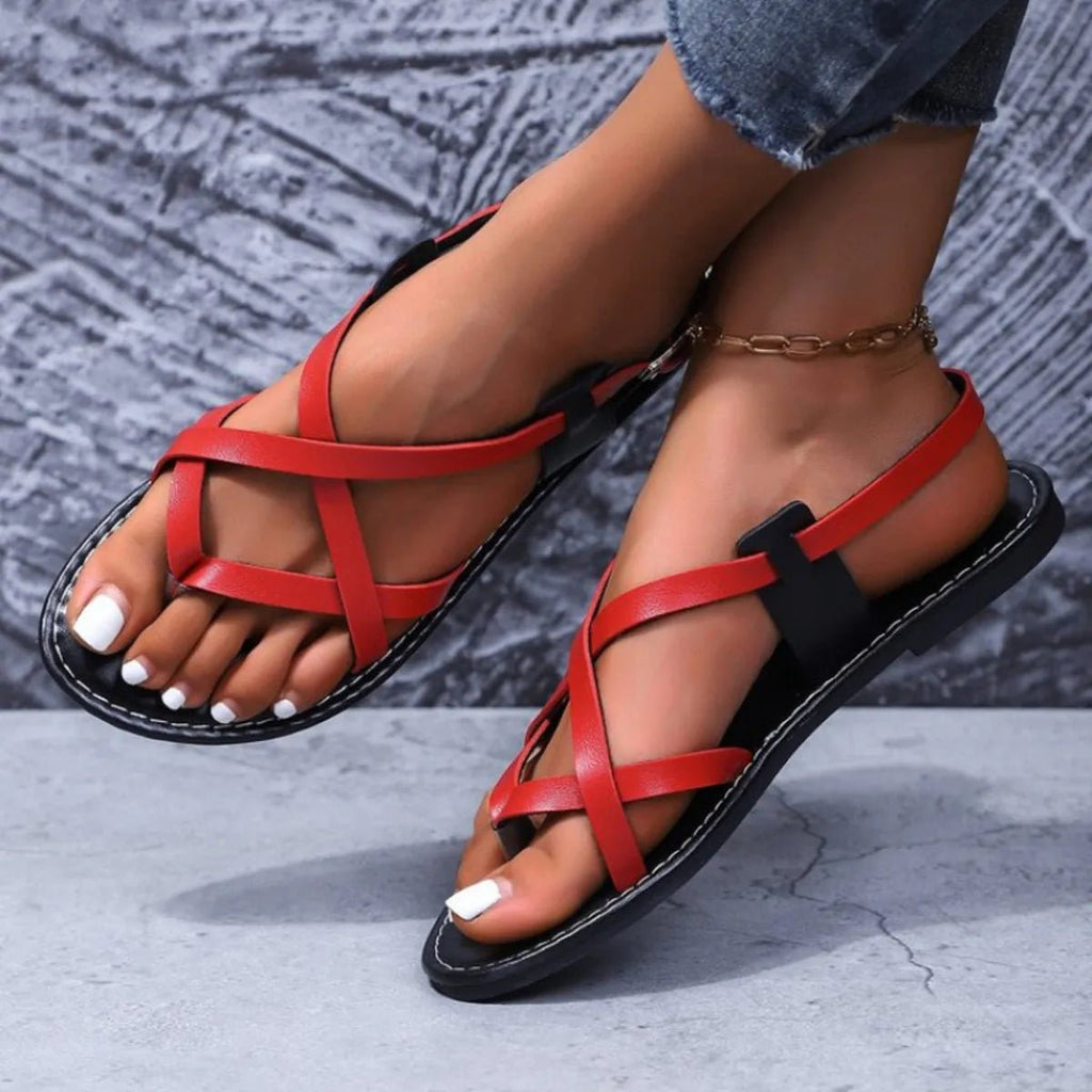 Women's faux leather flat sandals with strappy cross-strap design, perfect for casual summer wear.