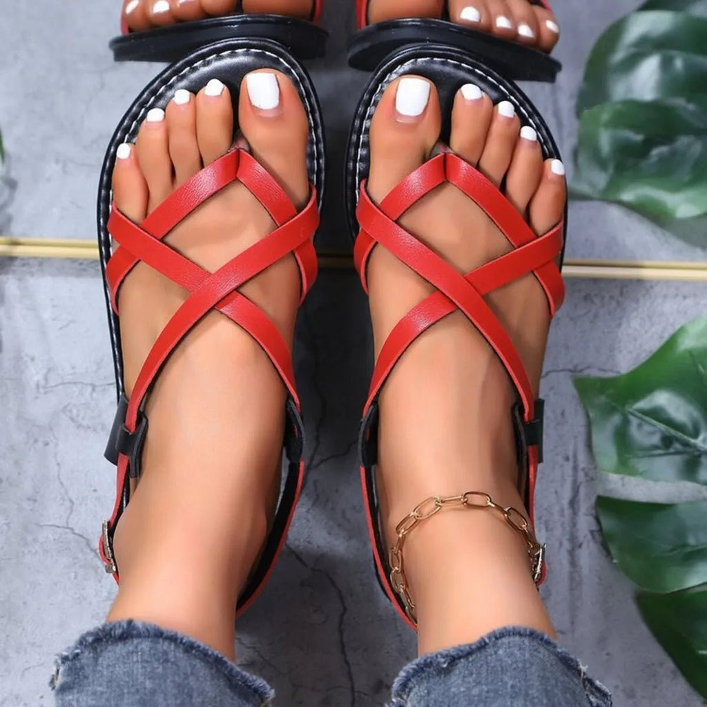 Women's faux leather flat sandals with strappy cross-strap design, comfortable and stylish shoe by Trendsi.