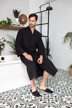 Men's Lotus Linen waffle spa bathrobe, lightweight and absorbent, shown hanging on a hook with a relaxed fit and soft texture.