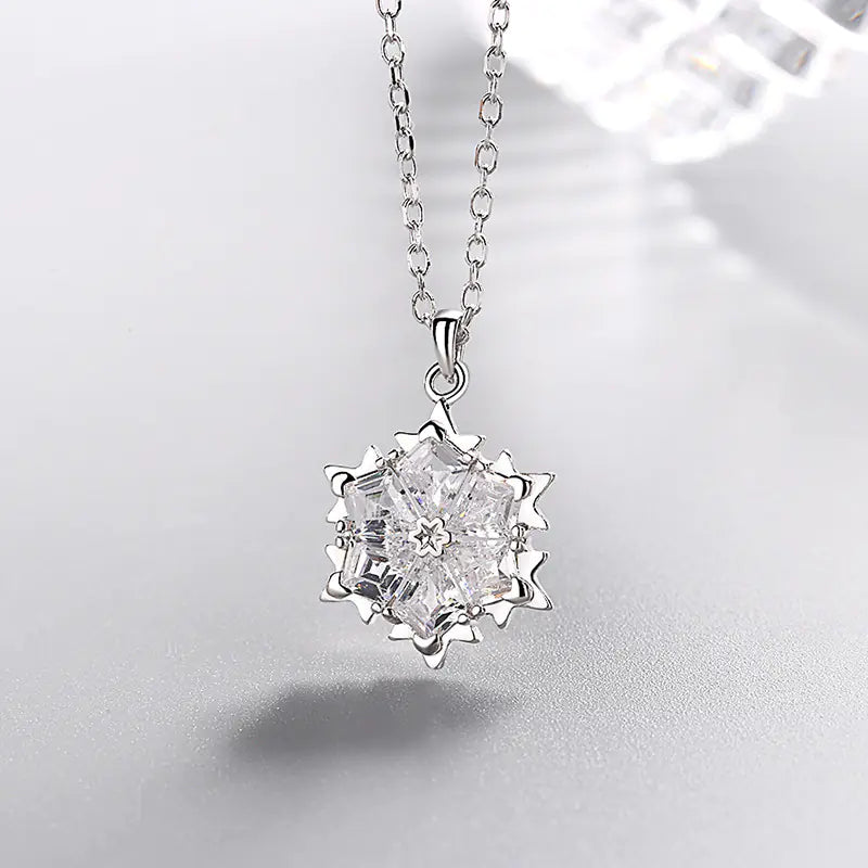 Silver snowflake necklace with diamond pendant, stylish jewelry piece showcasing a delicate winter-inspired design.
