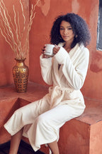 Women's plush bathrobe by Lotus Linen in tan color, featuring a soft, cozy fabric with a relaxed fit and shawl collar.
