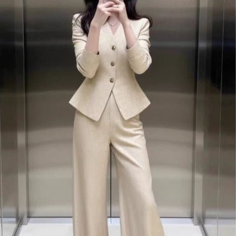 Beige waist-grabbing coat and wide-leg pants set by FitiqueFit, shown on a model, stylish and tailored for a modern look.