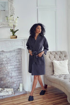 Women wearing a knee-length waffle robe from Lotus Linen, showcasing soft, cozy fabric and relaxed fit in a home setting.