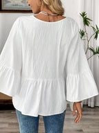 Women's 100% cotton V-neck bell sleeve blouse from Trendsi, showcasing a relaxed fit and stylish bell sleeves for effortless chic.