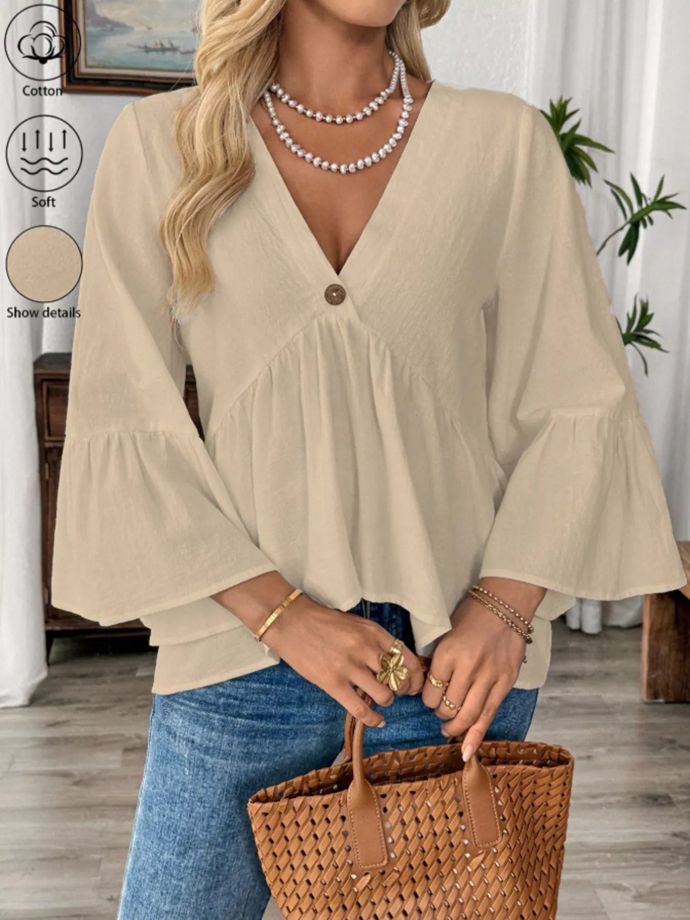 Women's white 100% cotton V-neck bell sleeve blouse from Trendsi, showcasing a relaxed fit and stylish bell sleeve design.