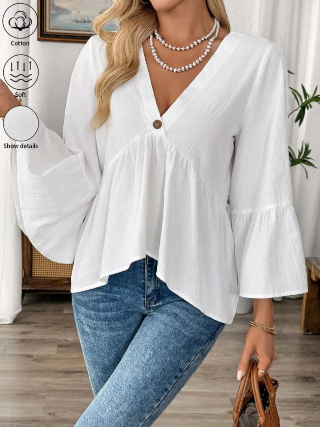 Women's white cotton V-neck blouse with bell sleeves, featuring a chic, effortless style perfect for casual or dressy occasions.