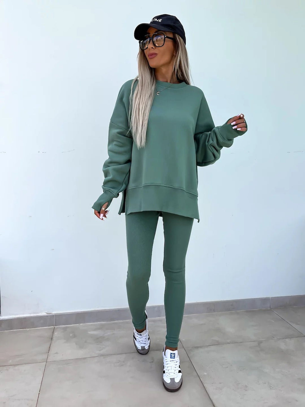 Women’s casual sweater suit by FitiqueFit with a loose split top and fitted trousers, perfect for stylish everyday wear.