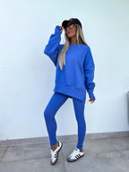 Women’s casual sweater suit by FitiqueFit with a loose split top and fitted trousers, styled for comfortable everyday wear.