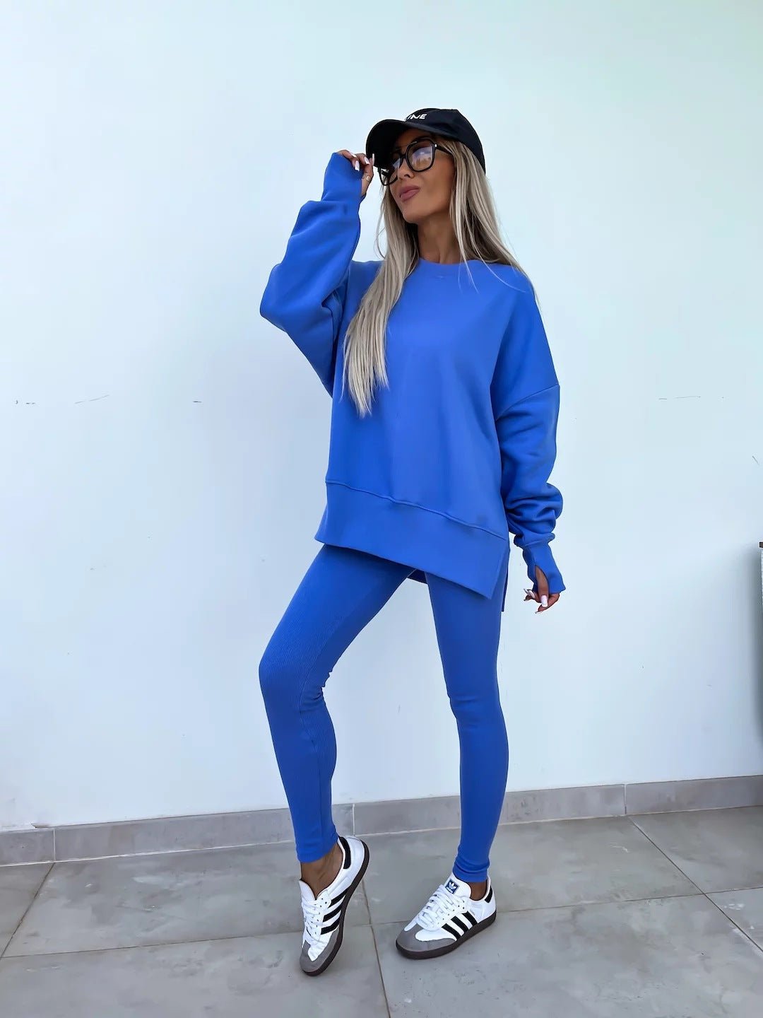 Women’s casual sweater suit by FitiqueFit with a loose split top and fitted trousers, styled for comfortable everyday wear.