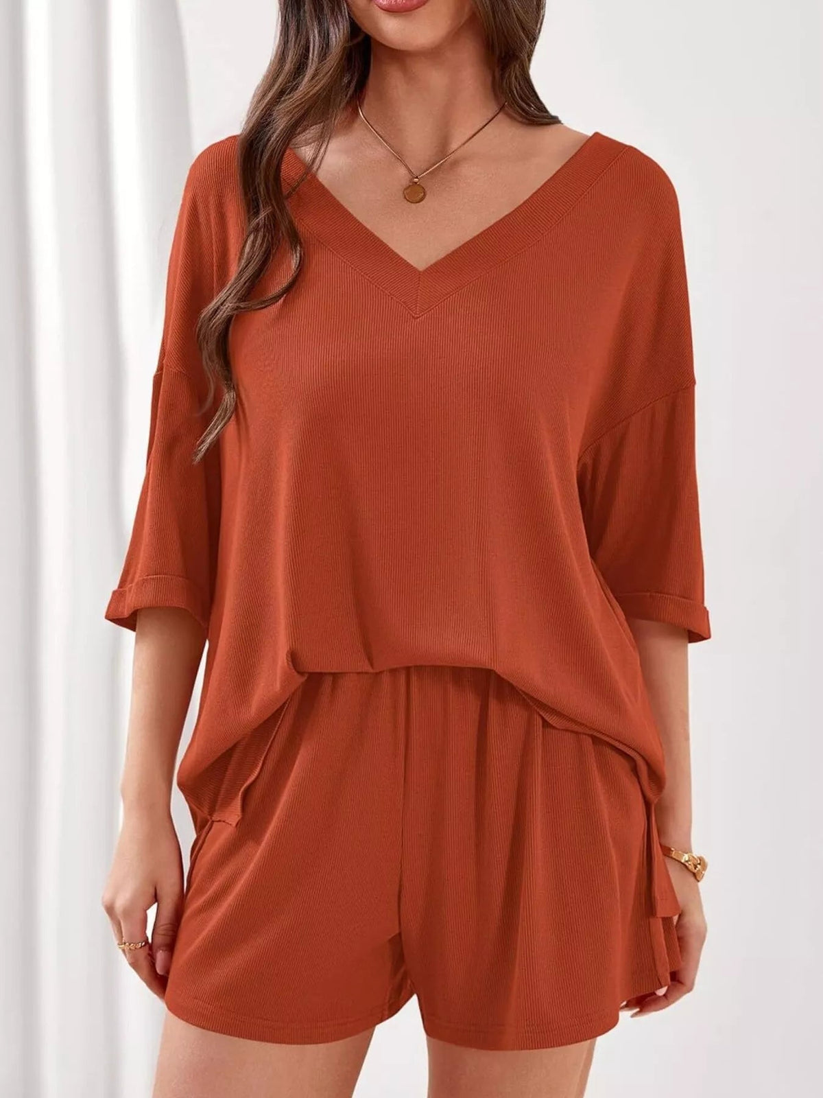 Women's casual V-neck top and shorts set by Plush Fashion Hub, solid color two-piece clothing outfit, perfect for relaxed wear.