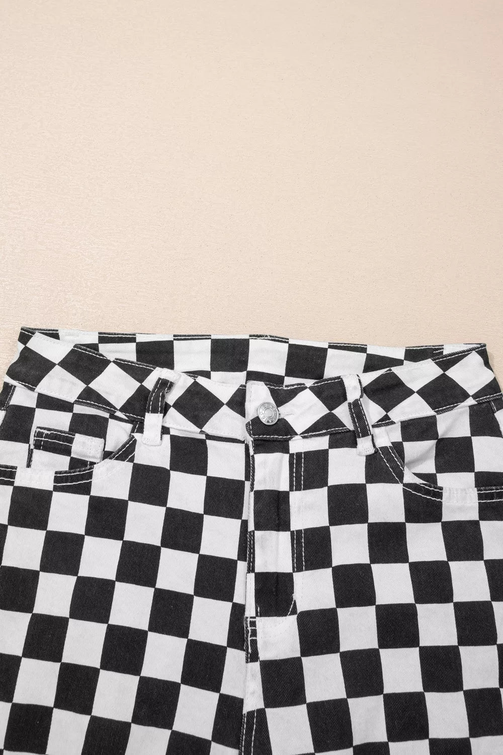 Women's checkerboard print distressed raw edge cropped jeans by Trendsi, featuring a bold pattern and frayed hem detail.