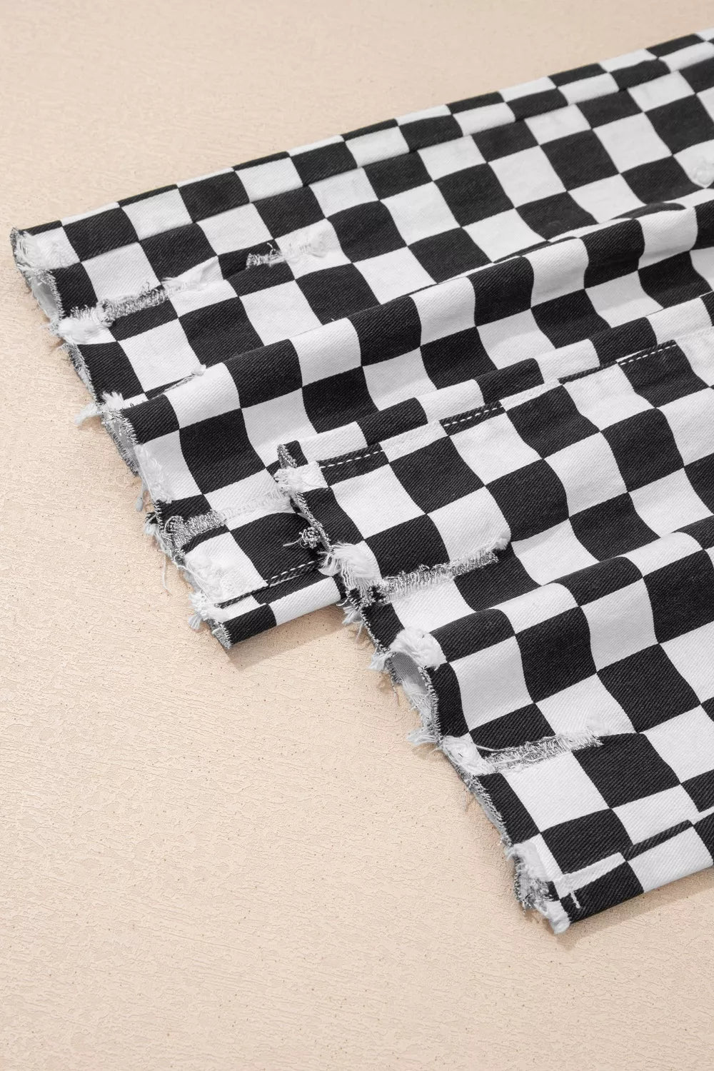 Women's checkerboard print distressed raw edge cropped jeans from Trendsi, featuring a classic checkerboard pattern and frayed hem.