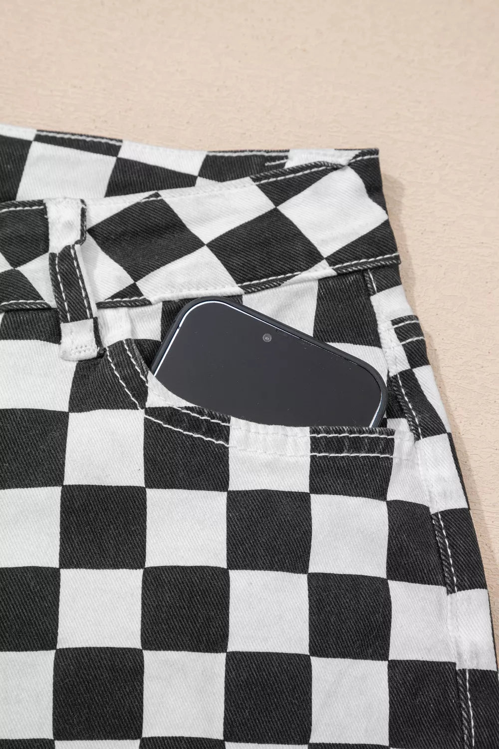 Women's checkerboard print distressed raw edge cropped jeans by Trendsi, showing the unique pattern and frayed hem detail.